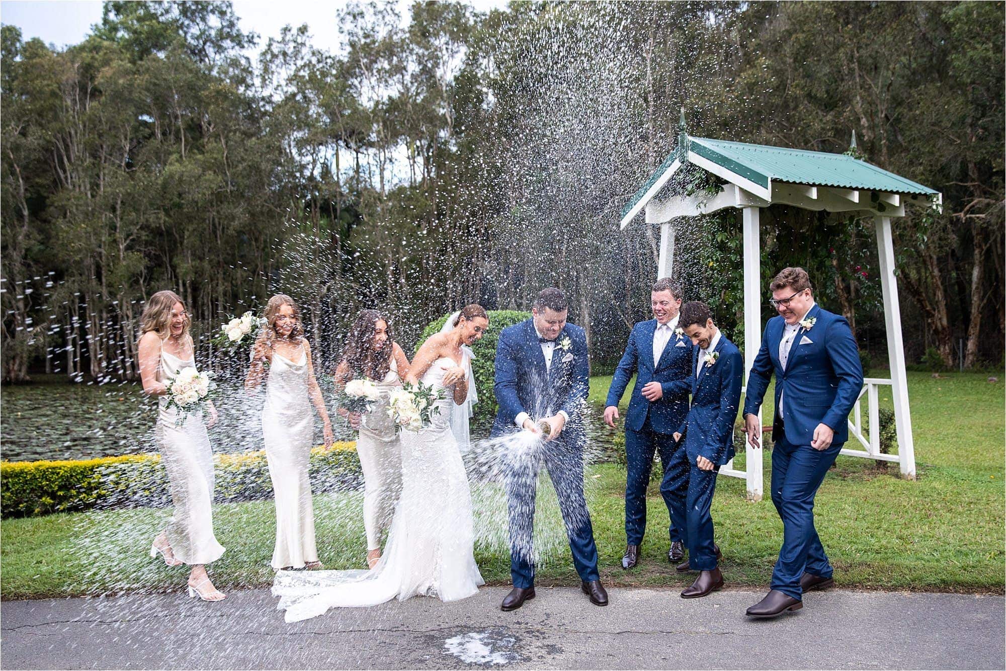 Bridal party spraying champagne during photos at Coolibah down Estate, by Mooi Photography.