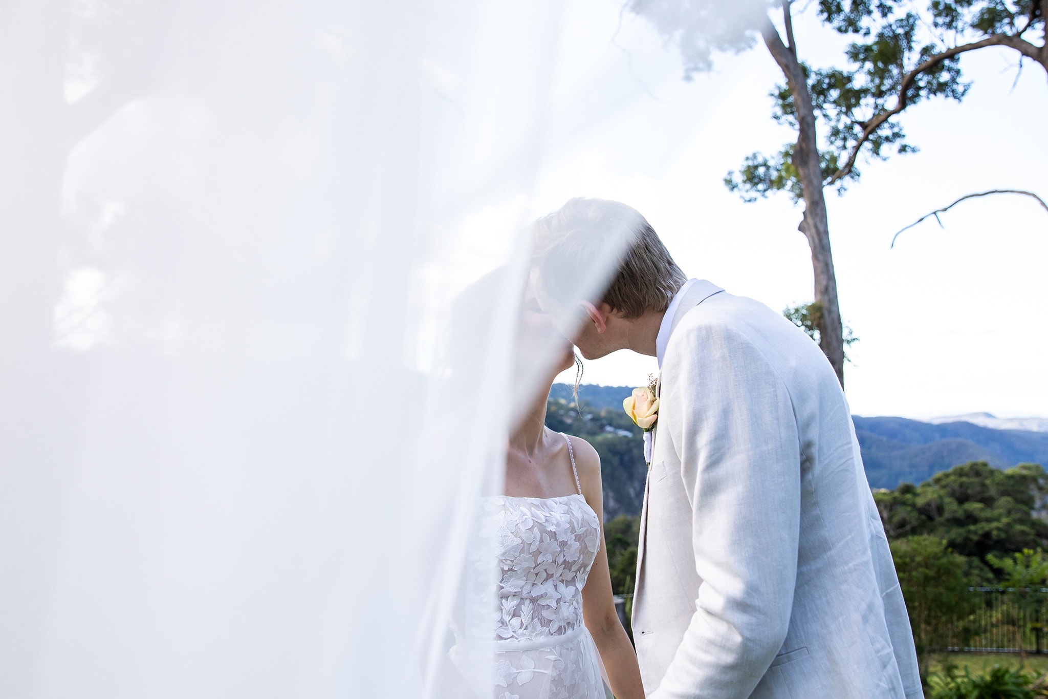 Bride and groom under wedding veil.